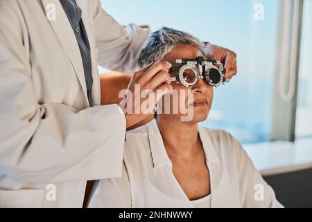 Esame oculare senior, optometristo e esame oculare medico di una donna anziana alla consultazione del medico. Visione, attenzione sanitaria e paziente anziana con Foto Stock
