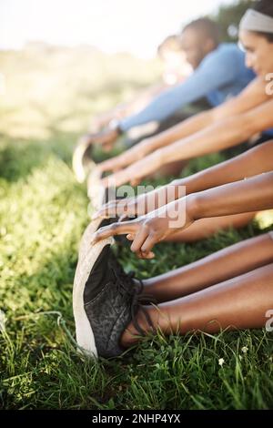 Lo stretching è obbligatorio. un gruppo di fitness che si allunga prima della loro corsa. Foto Stock