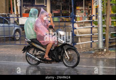 SAMUT PRAKAN, THAILANDIA, 21 2022 SETTEMBRE, coppia in impermeabile guidare sotto la pioggia Foto Stock