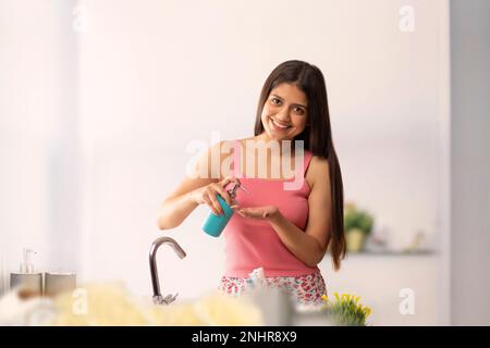 Donna che pulisce le mani con liquido lavarsi le mani in bagno Foto Stock