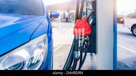 Rifornimento di auto SUV di lusso blu presso la stazione di servizio. Rifornire di carburante con benzina. Ugello di rifornimento carburante della pompa di benzina nella stazione di servizio. Industria della benzina. Foto Stock