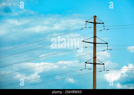 Asta telefonica e fili contro il cielo blu con nuvole Foto Stock