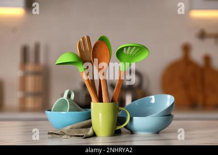 Set di diversi utensili da cucina e piatti in ceramica sul tavolo bianco in cucina Foto Stock