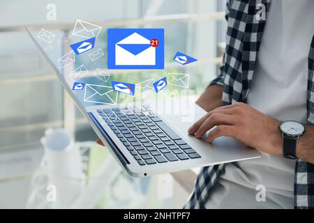 Uomo che invia e-mail tramite computer portatile a casa, in primo piano Foto Stock