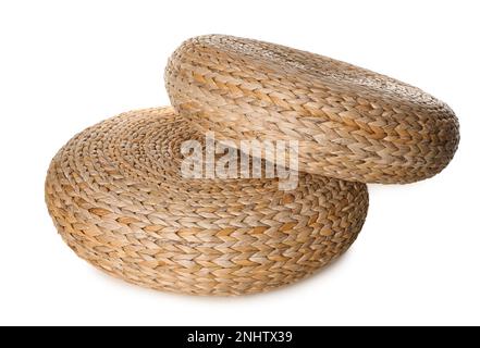 Due eleganti pouf in vimini su sfondo bianco Foto Stock