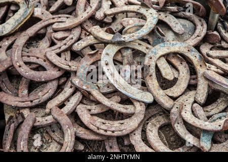 Pile di vecchi ferro di cavallo usati e arrugginiti. Messa a fuoco selettiva Foto Stock