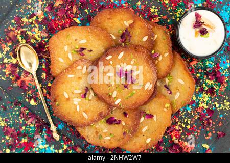 Succosi frittelle zuccherate i dolci anche chiamati Malpua, Pooa o Pua sono dolci tradizionali indiani Mithai bevuto, affondato, imbevuto o tuffato in formaggio di sciroppo di zucchero Foto Stock