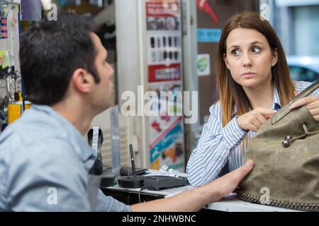 emale cobbler che parla con il cliente maschio Foto Stock