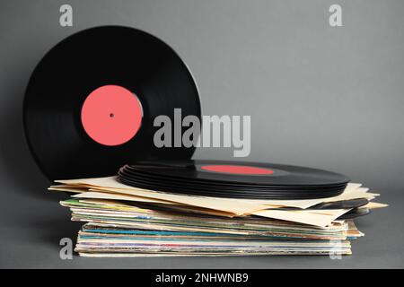 Pila di dischi in vinile vintage su sfondo grigio Foto Stock