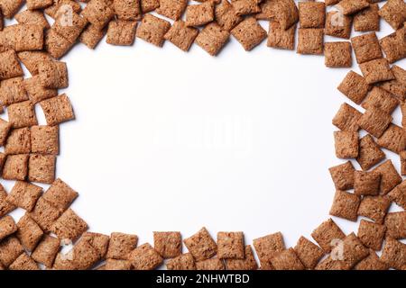 Cornice realizzata con deliziose coppette di cioccolato e mais su sfondo bianco, vista dall'alto. Spazio per il testo Foto Stock