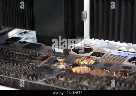 Taglio di lamiere in acciaio inox con macchina di taglio laser CNC. Messa a fuoco selettiva. Foto Stock