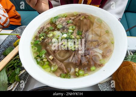 Pho, a base di brisket di manzo, tagliatelle e cipolla primaverile, è una zuppa vietnamita. Foto Stock