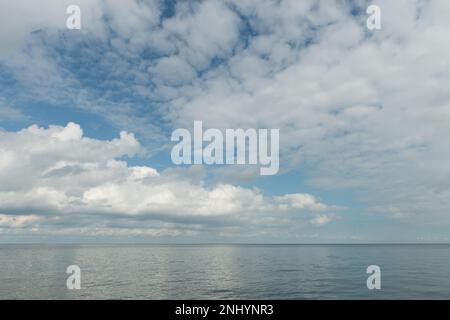 Acqua calma mare alta marea predomina come il cambiamento di fronte tempo basso vede il tempo piovoso nuvoloso dirigendo in questo modo spiaggia di mare guardando verso l'orizzonte Foto Stock