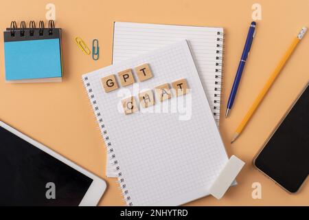 Lavora e studia il background con l'aiuto di un bot chatGPT. Parole in lettere di legno. Vista da tavolo con spazio di copia del notebook aperto. Chat GPT per lavorare e creare Foto Stock