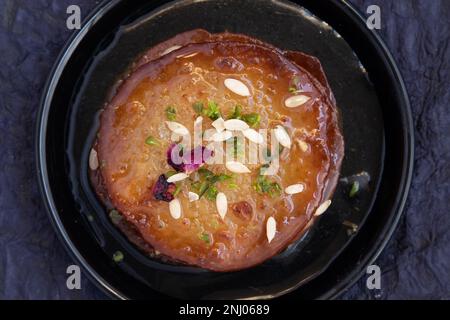 Succosi frittelle zuccherate i dolci anche chiamati Malpua, Pooa o Pua sono dolci tradizionali indiani Mithai bevuto, affondato, imbevuto o tuffato in formaggio di sciroppo di zucchero Foto Stock