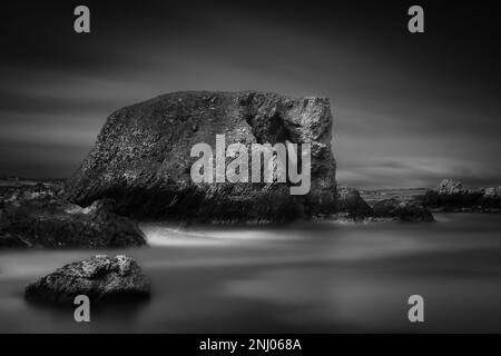 Formazione di rocce costiere, Elephant Rock a lunga esposizione con acqua e cielo sfocati, bianco e nero, Wild Atlantic Way, Antrim, Irlanda del Nord Foto Stock