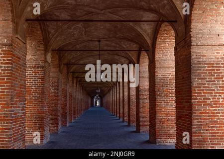 Colonne e archi in mattoni rossi nella Galleria degli antichi nella città di Sabbioneta. Lombardia, Italia Foto Stock