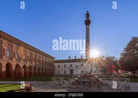 La colonna con statua di Minerva (colonna di Minerva) e Galleria degli antichi ai raggi del sole tramontato. Sabbioneta, Lombardia, Italia Foto Stock