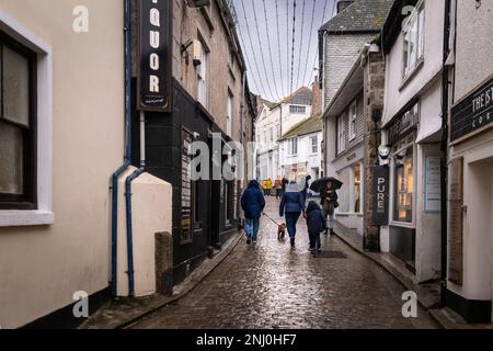 I vacanzieri che camminano lungo Fore Street durante la forte pioggia in bassa stagione a St Ives in Cornovaglia in Inghilterra nel Regno Unito. Foto Stock