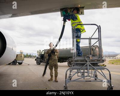 STATI UNITI Air Force Airman 1st Class Christopher Hernandez, 673d Logistics Readiness Squadron alimenta l'operatore di distribuzione, consegna un tubo di carburante a Royal Australian Air Force Corporal Tyron Houston, n. 2 tecnico di aerei Squadron, durante RED FLAG-Alaska 22-3 presso Joint base Elmendorf-Richardson, Alaska, 4 agosto 2022. L'alleanza USA-Australia è un'ancora per la pace e la stabilità nella regione dell'Indo-Pacifico e in tutto il mondo. Foto Stock