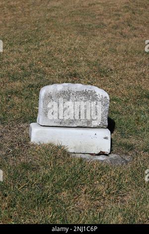 Una vecchia lapide usurata e intatta con un epitaffio bianco e spazio per il testo. Foto Stock