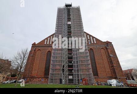 Wismar, Germania. 22nd Feb, 2023. La chiesa di San Nikolai ha riconquistato la sua corona di guglia rinnovata. L'esteso lavoro di ristrutturazione del sacro edificio tardo gotico, che è stato costruito nel 15th ° secolo come una chiesa per i marinai e pescatori e ancora forma la silhouette della città anseatica, ha avuto inizio quattro anni fa. Credit: Bernd Wüstneck/dpa/Alamy Live News Foto Stock