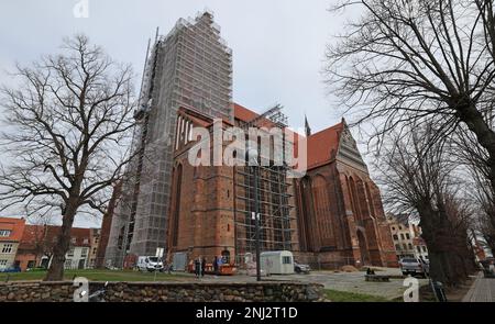 Wismar, Germania. 22nd Feb, 2023. La chiesa di San Nikolai ha riconquistato la sua corona di guglia rinnovata. L'esteso lavoro di ristrutturazione del sacro edificio tardo gotico, che è stato costruito nel 15th ° secolo come una chiesa per i marinai e pescatori e ancora forma la silhouette della città anseatica, ha avuto inizio quattro anni fa. Credit: Bernd Wüstneck/dpa/Alamy Live News Foto Stock