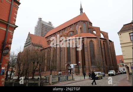 Wismar, Germania. 22nd Feb, 2023. La chiesa di San Nikolai ha riconquistato la sua corona di guglia rinnovata. L'esteso lavoro di ristrutturazione del sacro edificio tardo gotico, che è stato costruito nel 15th ° secolo come una chiesa per i marinai e pescatori e ancora forma la silhouette della città anseatica, ha avuto inizio quattro anni fa. Credit: Bernd Wüstneck/dpa/Alamy Live News Foto Stock