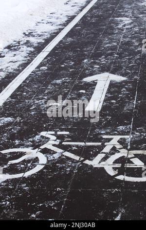 Simbolo di una pista ciclabile sul marciapiede nella neve Foto Stock