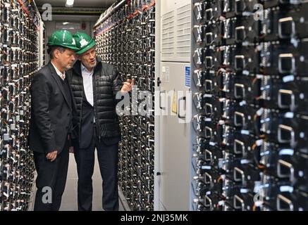 22 febbraio 2023, Brandeburgo, Spremberg: Robert Habeck (l. Bündnis 90/Die Grünen), ministro federale dell'economia e della protezione del clima, e Thorsten Kramer, capo della Lausitz Energie Bergbau AG e della Lausitz Energie Kraftwerke AG (LEAG), si trovano in un deposito di batterie durante una visita del sito della centrale elettrica a lignite di Schwarze Pumpe. Lo stesso giorno, Robert Habeck ha visitato quattro siti a Lusazia, nella regione di confine orientale tra il Brandeburgo e la Sassonia, per scoprire le varie misure di trasformazione nella regione mineraria dell'opencast. Un'innovativa combinazione di energia per lo stoccaggio dell'idrogeno Foto Stock