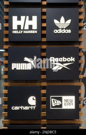 Logo dei marchi di calzature e abbigliamento più popolari all'interno di un negozio multimarca. Minsk, Bielorussia, 2022 Foto Stock
