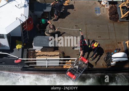 I membri del team di salvataggio dell'ostaggio dell'FBI guidano un cestino di salvataggio verso la barca durante la ricerca e l'addestramento di salvataggio dell'HRT dell'FBI nel porto di Charleston il 4 agosto 2022, a Charleston, South Carolina. La formazione HRT è stata sostenuta dalle agenzie marittime e di legge locali, mentre la priorità 1 Air Rescue è stata coinvolta nella formazione del personale dell'FBI per familiarizzare con le operazioni di salvataggio a bordo dell'elicottero H-60m Black Hawk. Foto Stock