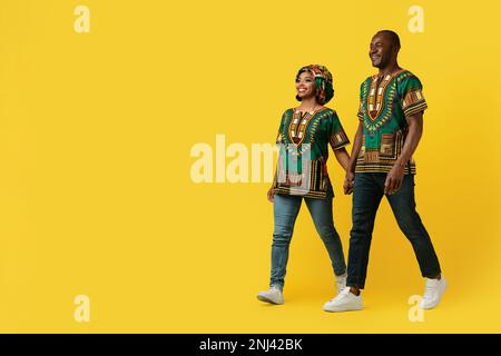 Amorevole uomo e donna africani che cammina sul giallo Foto Stock