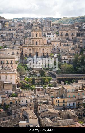 Modica, Italia-8 maggio 2022: Vista panoramica della caratteristica città di Modica e della sua cattedrale di San Giorgio in Sicilia durante una giornata nuvolosa Foto Stock