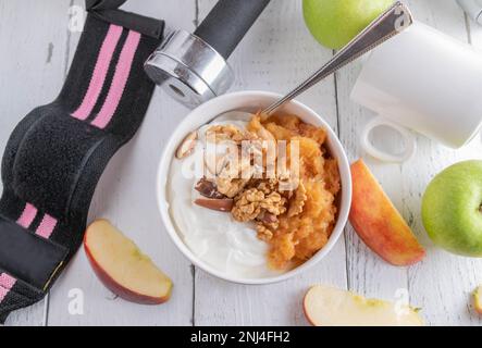 Piatto per la colazione fitness con yogurt greco, mele grattugiate e noci su sfondo bianco Foto Stock