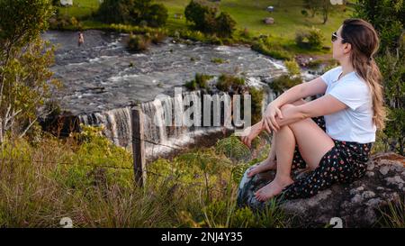 donna alle cascate che ammirano il panorama Foto Stock