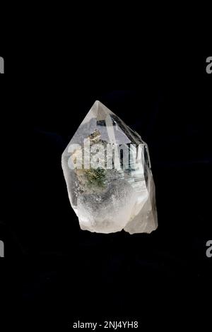 Primo piano di un pezzo di bel cristallo di quarzo chiaro Himalayano su sfondo nero Foto Stock