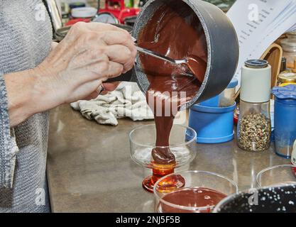 Lo chef versa la crema di cioccolato speciale di pesach con fragole e mirtilli in un recipiente speciale. Foto Stock