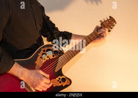 Vaduz, Liechtenstein, 13 gennaio 2023 l'artista suona con una chitarra acustica Ovation in rosso Foto Stock