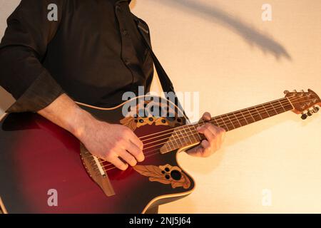 Vaduz, Liechtenstein, 13 gennaio 2023 l'artista suona con una chitarra acustica Ovation in rosso Foto Stock