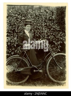 Originale fotografia vittoriana di una donna con la sua bicicletta in un giardino, indossando un boater, ciclismo d'epoca, circa 1897, zona di Worcester, REGNO UNITO Foto Stock