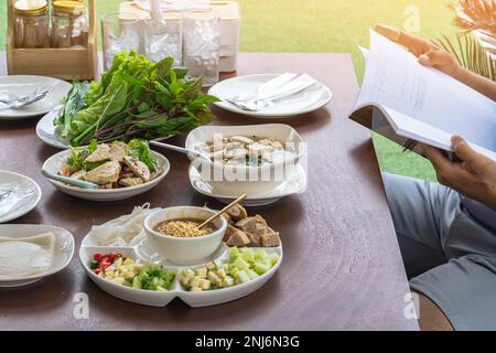 Insalata di salsiccia di maiale vietnamita piccante (Yum Moo Yor). Salsiccia di maiale insalata piccante tailandese e Vietnam cibo con altri piatti appetitosi e verdure sul bosco Foto Stock