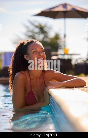 Donna sorridente in vacanza estiva relax in piscina Foto Stock