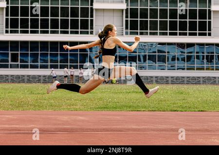 atleta femminile tripla salto in pista stadio Foto Stock