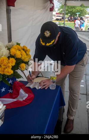 NORTH CHICAGO, il. Jason Williamson, Naval Station Great Lakes Commanding Officer (6 agosto 2022), compila una scheda dei giudici durante la sfilata dei North Chicago Community Days. Inaugurato nel 1911, NSGL è la più grande installazione di addestramento della Marina e la sede dell'unico Boot Camp della Marina. Situato su oltre 1600 acri di terreno affacciato sul Lago Michigan, l'installazione comprende 1.153 edifici di cui 39 nel Registro Nazionale dei luoghi storici. NSGL supporta oltre 50 comandi ed elementi locatari e oltre 20.000 marinai, marines, soldati e civili DoD che vivono e lavorano all'installazione. Foto Stock