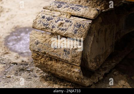 Il bulldozer si cinge nella sabbia e nell'argilla dopo i lavori in terra. Primo piano. Foto Stock