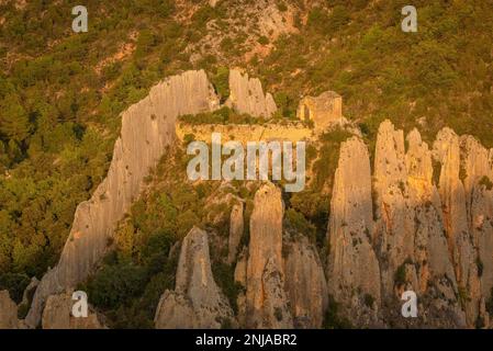 Particolare del Roques de la Vila, a Finestres (noto anche come Muralla de Finestres) e l'eremo di San Vicente tra le rocce al tramonto, Spagna Foto Stock