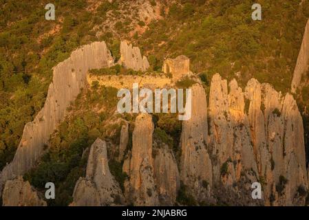 Particolare del Roques de la Vila, a Finestres (noto anche come Muralla de Finestres) e l'eremo di San Vicente tra le rocce al tramonto, Spagna Foto Stock