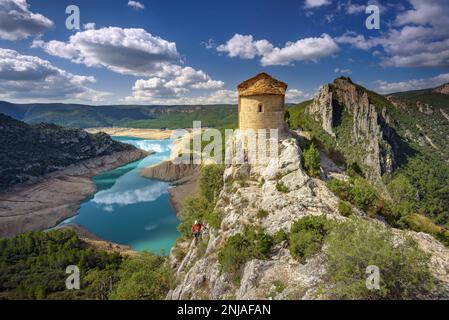 Eremo di la Pertusa su una scogliera sopra il bacino idrico di Canelles con pochissima acqua durante la siccità del 2022 (la Noguera, Lleida, Catalogna, Spagna) Foto Stock