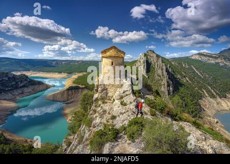 Eremo di la Pertusa su una scogliera sopra il bacino idrico di Canelles con pochissima acqua durante la siccità del 2022 (la Noguera, Lleida, Catalogna, Spagna) Foto Stock